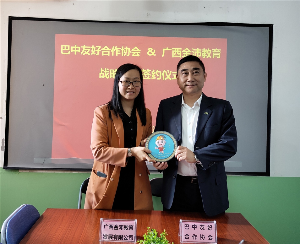 廣西金沛教育校長張金雪女士向巴中友好合作協會副會長江弘贈送吉祥物“金小沛”